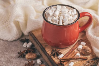 Parlak kırmızı zemin üzerine eşarp ile ahşap kesme tahtası üzerinde hatmi ile sıcak kakao fincan. Kış ısınma içki. Yatay görünüm. Yakın çekim