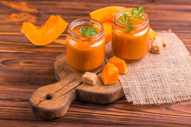 Maydanoz çuval bezi peçete ile eski rustik kesme tahtası üzerinde cam kavanoza Taze kabak güler yüzlü. Ahşap arka plan. Yatay görünüm. Kopya alanı