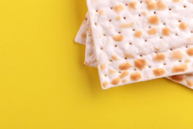 Parlak sarı zemin üzerine geleneksel Yahudi koşer matzo. Uzay kopyalayın. Üstten görünüm