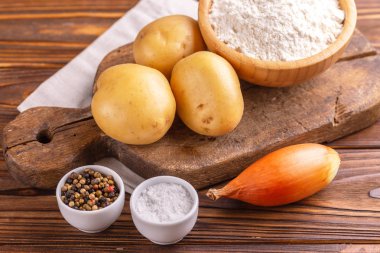 Geleneksel patates gözlemesi ya da latke Hanuka kutlaması gıda vintage kesme tahtası üzerinde için malzemeler. Rustik ahşap arka plan