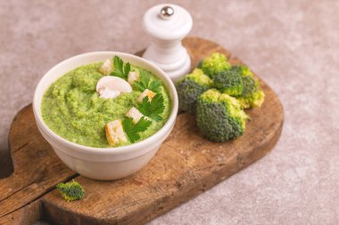 Lezzetli taze brokoli çorbası malzemeler kesme tahtası üzerinde kil kase ezilmiş. Sağlıklı gıda kavramı. Gri mermer zemin. Yatay görünüm. Kopya alanı