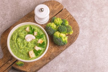 Lezzetli taze brokoli çorbası malzemeler kesme tahtası üzerinde kil kase ezilmiş. Sağlıklı gıda kavramı. Gri mermer zemin. Yatay görünüm. Kopya alanı