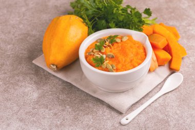 Bright lezzetli balkabağı çorbası malzemeler kil kase ezilmiş. Sağlıklı gıda kavramı. Gri mermer zemin. Yatay görünüm. Kopya alanı