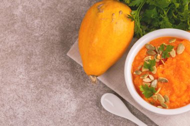 Bright lezzetli balkabağı çorbası malzemeler kil kase ezilmiş. Sağlıklı gıda kavramı. Gri mermer zemin. Üstten görünüm. Kopya alanı