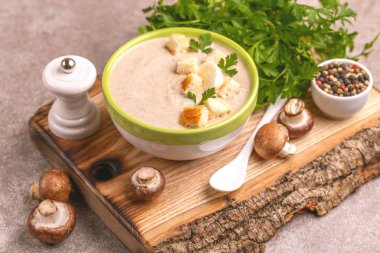 Malzemelerin kesme tahtası üzerine kil kase lezzetli pureed mantar çorbası. Sağlıklı gıda kavramı. Gri ahşap arka plan. Yatay görünüm. Kopya alanı