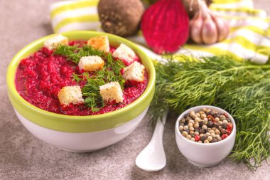 Bright lezzetli kırmızı pancar çorbası malzemeler kil kase ezilmiş. Sağlıklı gıda kavramı. Gri mermer zemin. Yatay görünüm. Kopya alanı