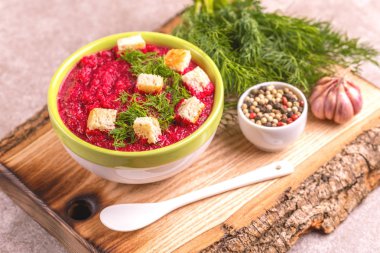 Bright lezzetli kırmızı pancar çorbası malzemeler ahşap kesme tahtası üzerinde kil kase ezilmiş. Sağlıklı gıda kavramı. Gri mermer zemin. Yatay görünüm. Kopya alanı