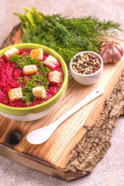 Bright lezzetli kırmızı pancar çorbası malzemeler ahşap kesme tahtası üzerinde kil kase ezilmiş. Sağlıklı gıda kavramı. Gri mermer zemin. Yatay görünüm. Kopya alanı