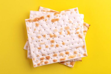 Parlak sarı zemin üzerine geleneksel Yahudi koşer matzo. Uzay kopyalayın. Üstten görünüm