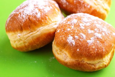 Parlak yeşil zemin üzerine pudra şekeri ile lezzetli tatlı çörek. Geleneksel Yahudi tatlı Hanukkah çanak