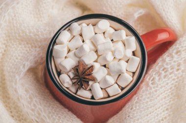 Parlak kırmızı fincan sıcak kakao ve marshmallow ile arka plan üzerinde sıcak eşarp. Kış ısınma içki. Üstten görünüm. Yakın çekim