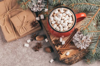 Sıcak kakao ile hatmi ile Noel dekorasyonları ahşap kesme tahtası üzerinde kırmızı fincan. Üstten görünüm. Kopya alanı