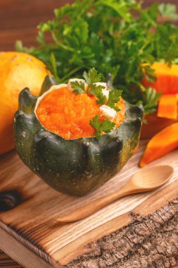 Parlak lezzetli püresi kabak çorbası malzemeler ile delikli bir kabak görev yaptı. Sağlıklı gıda kavramı. Rustik ahşap arka plan. Yatay görünüm. Yakın çekim