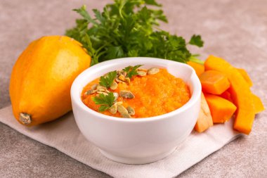 Bright lezzetli balkabağı çorbası malzemeler kil kase ezilmiş. Sağlıklı gıda kavramı. Gri mermer zemin. Yatay görünüm. Kopya alanı