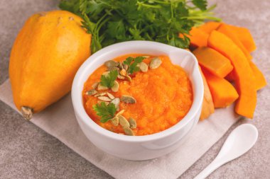 Bright lezzetli balkabağı çorbası malzemeler kil kase ezilmiş. Sağlıklı gıda kavramı. Gri mermer zemin. Yatay görünüm. Kopya alanı