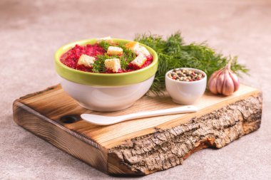 Bright lezzetli kırmızı pancar çorbası malzemeler ahşap kesme tahtası üzerinde kil kase ezilmiş. Sağlıklı gıda kavramı. Gri mermer zemin. Yatay görünüm. Kopya alanı