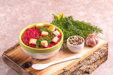 Bright lezzetli kırmızı pancar çorbası malzemeler ahşap kesme tahtası üzerinde kil kase ezilmiş. Sağlıklı gıda kavramı. Gri mermer zemin. Yatay görünüm. Kopya alanı