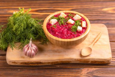 Bright lezzetli kırmızı pancar çorbası kesme tahtası üzerinde malzemelerle ahşap kase ezilmiş. Sağlıklı gıda kavramı. Rustik ahşap arka plan. Yatay görünüm. Kopya alanı