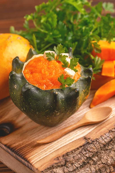 Parlak lezzetli püresi kabak çorbası malzemeler ile delikli bir kabak görev yaptı. Sağlıklı gıda kavramı. Rustik ahşap arka plan. Yatay görünüm. Yakın çekim