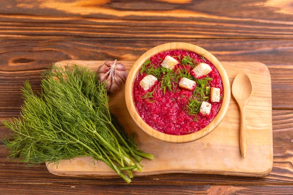 Bright lezzetli kırmızı pancar çorbası kesme tahtası üzerinde malzemelerle ahşap kase ezilmiş. Sağlıklı gıda kavramı. Rustik ahşap arka plan. Üstten görünüm. Kopya alanı