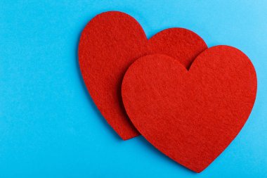 Parlak mavi zemin üzerine iki kırmızı keçe kalp. St. Valentine's day. Kopya alanı