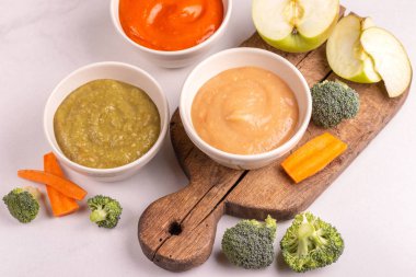 Varyasyon bebek maması vintage kesme tahtası üzerinde malzemelerle kil kase ezilmiş. Beyaz mermer zemin. Kopya alanı