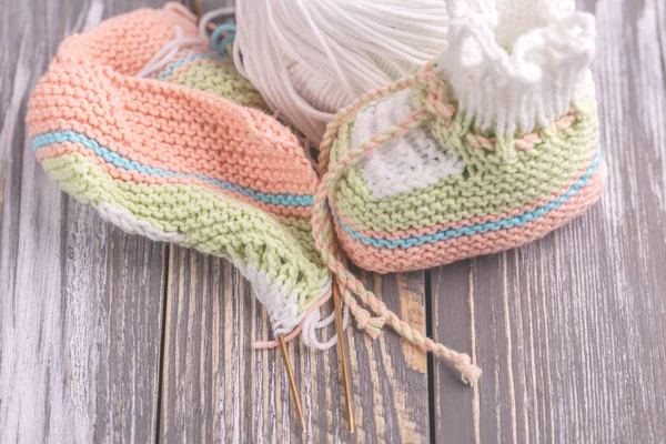 Knitted Baby Booties Yarn Needles Gray Rustic Wooden Background Warm — Stock Photo, Image