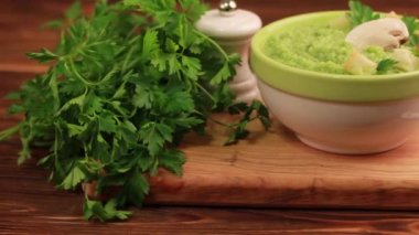 Lezzetli taze brokoli çorbası malzemeler kesme tahtası üzerinde kil kase ezilmiş. Sağlıklı gıda kavramı. Rustik ahşap arka plan. Yatay görünüm.