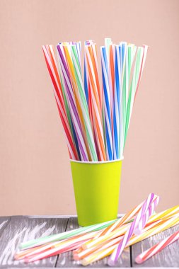 Kağıt bardak ahşap arka plan üzerinde renkli plastik çöp. Olay ve parti malzemeleri. Toprak kirliliği kavramı