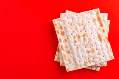 Parlak kırmızı zemin üzerine geleneksel Yahudi koşer matzo. Uzay kopyalayın. Üstten görünüm