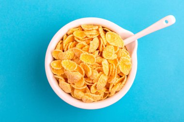 Gevrek Mısır gevreği kil parlak mavi arka plan üzerinde top. Sağlıklı tahıllar kahvaltı. Kopya alanı