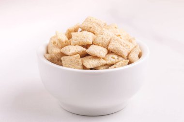 Işık kil kase mısır yastıkları arka plan beyaz. Sağlıklı tahıllar kahvaltı. Kopya alanı