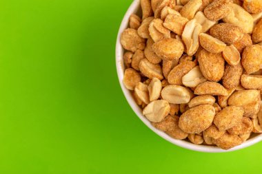 Kağıt bardak parlak yeşil zemin üzerine kavrulmuş fıstık. Film aperatifler. Kopya alanı