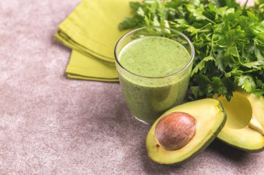 Cam ile mermer gri arka plan üzerine maydanoz taze avokado güler yüzlü. Yatay görünüm. Kopya alanı