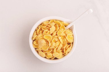 Gevrek Mısır gevreği kil kase ışık arka plan mermer. Sağlıklı tahıllar kahvaltı. Kopya alanı