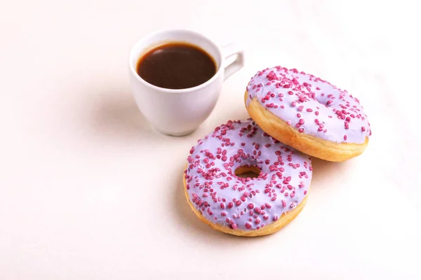 Два Восхитительных Лиловых Пончика Брызгами Чашкой Кофе Светлом Мраморном Фоне — стоковое фото