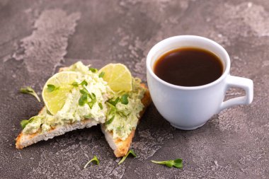 Tost avokado pate, taze microgreen ve kahve koyu beton zemin üzerine. Sağlıklı ve lezzetli kahvaltı