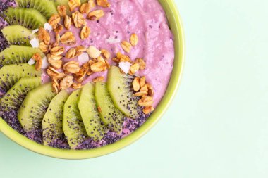 Blueberry smoothie, taze kivi, granola ve açık yeşil renkli üzerinde haşhaş tohumu ile Acai kase. Sağlıklı gıda kavramı. Uzay kopyalayın. Seçici odak