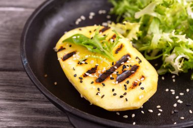 Vejetaryen salata Izgara mango, taze frisee ve susam dökme demir tavada. Koyu ahşap arka plan. Sağlıklı gıda kavramı.