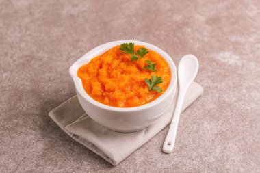 Bright lezzetli pureed havuç çorbası peçete kil kase. Sağlıklı gıda kavramı. Gri mermer zemin. Yatay görünüm. Kopya alanı