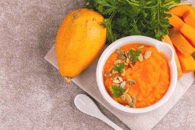 Bright lezzetli balkabağı çorbası malzemeler kil kase ezilmiş. Sağlıklı gıda kavramı. Gri mermer zemin. Üstten görünüm. Kopya alanı