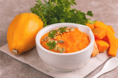 Bright lezzetli balkabağı çorbası malzemeler kil kase ezilmiş. Sağlıklı gıda kavramı. Gri mermer zemin. Yatay görünüm. Kopya alanı