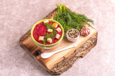 Bright lezzetli kırmızı pancar çorbası malzemeler ahşap kesme tahtası üzerinde kil kase ezilmiş. Sağlıklı gıda kavramı. Gri mermer zemin. Üstten görünüm. Kopya alanı