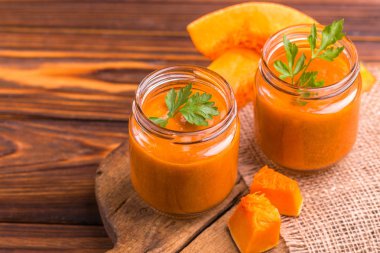 Maydanoz çuval bezi peçete ile eski rustik kesme tahtası üzerinde cam kavanoza Taze kabak güler yüzlü. Ahşap arka plan. Yatay görünüm. Kopya alanı