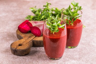 Parlak kırmızı pancar pancar ve maydanoz kesme tahtası üzerinde taze parçaları ile diş içinde güler yüzlü. Gri kayrak arka plan. Yatay görünüm. Kopya alanı