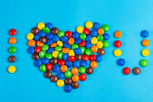 Doces Coloridos Chocolate Vitrificado Dispostos Amo Fundo Azul Brilhante Dia — Fotografia de Stock