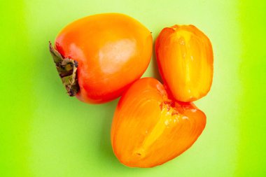 Lezzetli olgun hurma meyve parlak yeşil zemin üzerine. Mevsim kış meyve. Kopya alanı