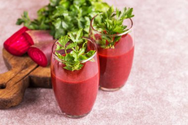 Parlak kırmızı pancar pancar ve maydanoz kesme tahtası üzerinde taze parçaları ile diş içinde güler yüzlü. Gri kayrak arka plan. Yatay görünüm. Kopya alanı