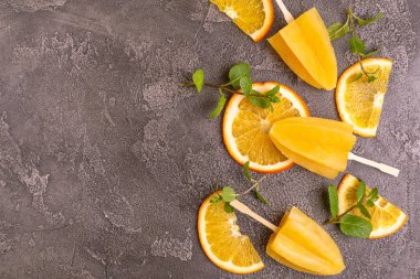 Gri beton zemin üzerine olgun turuncu ve taze nane ile ev yapımı turuncu buzlu şeker. Sağlıklı tatlılar. Laktoz ücretsiz dondurma.