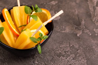 Gri beton zemin üzerine olgun turuncu ve taze nane ile ev yapımı turuncu buzlu şeker. Sağlıklı tatlılar. Laktoz ücretsiz dondurma.